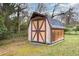 Wooden storage shed featuring classic gable roof with double doors at 2246 Hillandale Rd, Durham, NC 27705