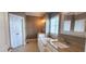 Elegant bathroom featuring double sinks, a soaking tub, and neutral tile flooring at 2429 Falls River Ave, Raleigh, NC 27614