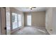 Bright bedroom featuring neutral carpet, ceiling fan, and natural light from large windows at 2429 Falls River Ave, Raleigh, NC 27614
