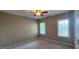 A bright bedroom featuring plush carpeting, neutral walls, and a ceiling fan for added comfort at 2429 Falls River Ave, Raleigh, NC 27614