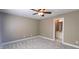 Neutral-toned bedroom with carpet, a ceiling fan, and an en-suite bathroom entrance at 2429 Falls River Ave, Raleigh, NC 27614