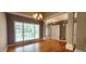Open dining room with hardwood flooring, chandelier, and large window at 2429 Falls River Ave, Raleigh, NC 27614
