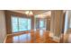 Hardwood floors, chandelier, and large window in the formal dining area at 2429 Falls River Ave, Raleigh, NC 27614