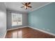 Bedroom with hardwood floors, a ceiling fan, window, and light blue accent wall at 2505 Egypt Mountain Rd, Kittrell, NC 27544