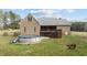 Rear view of the brick home featuring an above ground pool, deck, and outdoor entertainment spaces at 2505 Egypt Mountain Rd, Kittrell, NC 27544