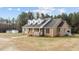 Brick home showcasing dormer windows and a covered front porch surrounded by mature trees at 2505 Egypt Mountain Rd, Kittrell, NC 27544