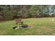 Backyard fire pit with rustic bench seating, perfect for cozy outdoor gatherings and enjoying nature at 2505 Egypt Mountain Rd, Kittrell, NC 27544