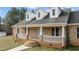 Close up of a brick house with a covered front porch and white railings at 2505 Egypt Mountain Rd, Kittrell, NC 27544