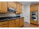 Kitchen featuring wooden cabinets, granite countertops, tile backsplash, and stainless steel appliances at 2505 Egypt Mountain Rd, Kittrell, NC 27544