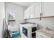 Functional laundry room with modern appliances, ample storage, and a bright window for natural light at 251 North Crest Dr, Chapel Hill, NC 27517