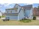 A view of the backyard with blue siding, a wooden deck, and green grass at 2601 Forestville Rd, Wake Forest, NC 27587