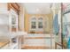 Bright bathroom featuring a soaking tub under arched windows and a glass-enclosed shower at 2601 Forestville Rd, Wake Forest, NC 27587