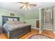A spacious bedroom with hardwood floors, a statement ceiling fan, and an adjoining staircase at 2601 Forestville Rd, Wake Forest, NC 27587