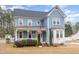 Charming two-story home with blue siding, a welcoming porch, and manicured landscaping at 2601 Forestville Rd, Wake Forest, NC 27587