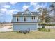 The side of this blue home has arched windows and a lush, green yard at 2601 Forestville Rd, Wake Forest, NC 27587
