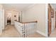 Second floor hallway with wood banister, carpet flooring, and wood doors at 2601 Forestville Rd, Wake Forest, NC 27587