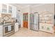 Well-lit kitchen features stainless steel appliances, tile flooring, and custom wood cabinets at 2601 Forestville Rd, Wake Forest, NC 27587