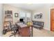 Well-lit office with large desk, leather couch, a wall-mounted bookshelf and carpeted floors at 2601 Forestville Rd, Wake Forest, NC 27587