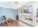 A cozy screened porch with blue walls, two chairs, and a ceiling fan at 2601 Forestville Rd, Wake Forest, NC 27587