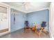 A cozy screened porch with blue walls, two chairs, and a ceiling fan at 2601 Forestville Rd, Wake Forest, NC 27587