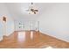 Open-concept living room with hardwood floors, a ceiling fan, and large windows providing ample light at 2776 Jordan Ct, Creedmoor, NC 27522