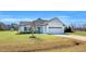 Attractive single-story home with white siding, a blue front door, and a two car garage at 28 Sandcastle Ln, Four Oaks, NC 27524