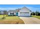 Charming one-story home with white siding, a bright blue door, and a spacious two car garage at 28 Sandcastle Ln, Four Oaks, NC 27524