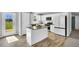 Modern kitchen features white cabinets, stainless steel appliances, granite countertops, and a central island at 28 Sandcastle Ln, Four Oaks, NC 27524