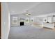 Bright living room with a fireplace, large windows, and an open concept leading to the kitchen at 28 Sandcastle Ln, Four Oaks, NC 27524