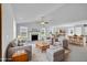 Bright living room featuring a fireplace, ceiling fan, and seamlessly integrates a dining area and a modern kitchen with bar seating at 28 Sandcastle Ln, Four Oaks, NC 27524