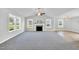 Open living room with fireplace, multiple windows, and seamless flow to the kitchen featuring a center island at 28 Sandcastle Ln, Four Oaks, NC 27524
