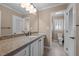 Well-lit bathroom featuring a granite countertop, white cabinetry, and tile floors at 3001 Blanche Dr, Burlington, NC 27215