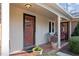 Inviting front porch featuring neutral siding, brick flooring, and decorative potted plants at 3001 Blanche Dr, Burlington, NC 27215