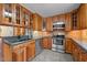 Kitchen featuring stainless steel appliances, dark countertops, and light wood cabinets at 3001 Blanche Dr, Burlington, NC 27215