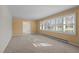 Sun-filled living room with tan walls, large windows, and view to dining room at 3001 Blanche Dr, Burlington, NC 27215