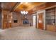 Carpeted living room with brick fireplace, wood paneled ceiling, and wood trim at 3001 Blanche Dr, Burlington, NC 27215
