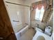 Tiled bathroom showcasing a bathtub, toilet, and vanity with sink near a window at 3015 Nc Hwy 87 South, Graham, NC 27253