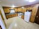 Traditional kitchen with wood cabinets, white appliances, and ample countertop space at 3015 Nc Hwy 87 South, Graham, NC 27253