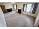 Sunlit living room featuring carpeted floors, a fireplace, and multiple windows at 3015 Nc Hwy 87 South, Graham, NC 27253