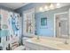 Bathroom with double vanity, toilet, full mirror and blue llama themed shower curtain at 307 Kellyridge Dr, Apex, NC 27502