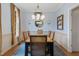 Well-lit dining room featuring a rustic wood table, modern chandelier, and ample natural light from the window at 307 Kellyridge Dr, Apex, NC 27502