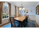 Elegant dining room with wainscoting, wood table, stylish chandelier, and large windows with view at 307 Kellyridge Dr, Apex, NC 27502