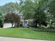 Traditional brick two-story home with manicured lawn, mature trees, and a welcoming blue front door at 307 Kellyridge Dr, Apex, NC 27502