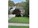 Charming two-story brick home featuring a manicured lawn, lush trees and a delightful periwinkle front door at 307 Kellyridge Dr, Apex, NC 27502