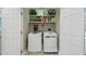 Laundry room with side by side washer and dryer, storage shelves and bi-fold closet doors at 307 Kellyridge Dr, Apex, NC 27502
