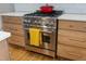 Close up of a stainless steel stove with wooden drawers and a red pot on top, showcasing modern kitchen design at 307 Kellyridge Dr, Apex, NC 27502