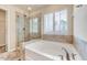 Relaxing bathroom with a soaking tub and separate glass shower, enhanced by natural light at 3162 Retama Run # 231, Apex, NC 27562