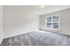 Bright bedroom with gray carpet, neutral walls, and a large window that provides ample natural light at 3162 Retama Run # 231, Apex, NC 27562
