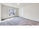 Light-filled bedroom with a large window, neutral walls, and comfortable gray carpeting at 3162 Retama Run # 231, Apex, NC 27562