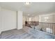 Bright loft featuring neutral paint, gray carpet, and a decorative railing overlooking the lower level at 3162 Retama Run # 231, Apex, NC 27562